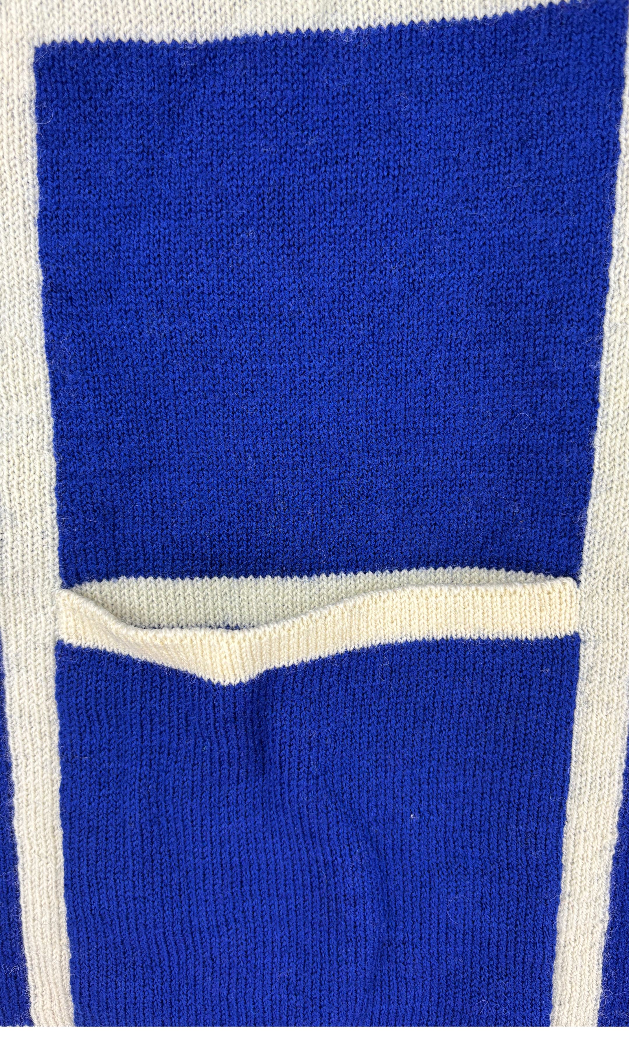 Detailansicht der Taschen der hochwertigen blau weiß karierten Alpaka-Strickjacke für Herren.