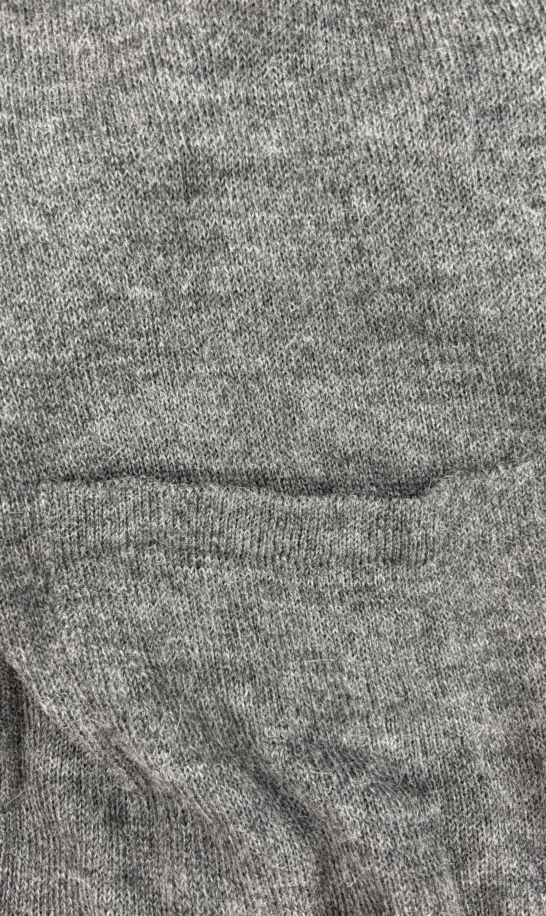 Taschenansicht der grauen Alpaka-Strickjacke für Herren– weiche, edle Stricktextur.