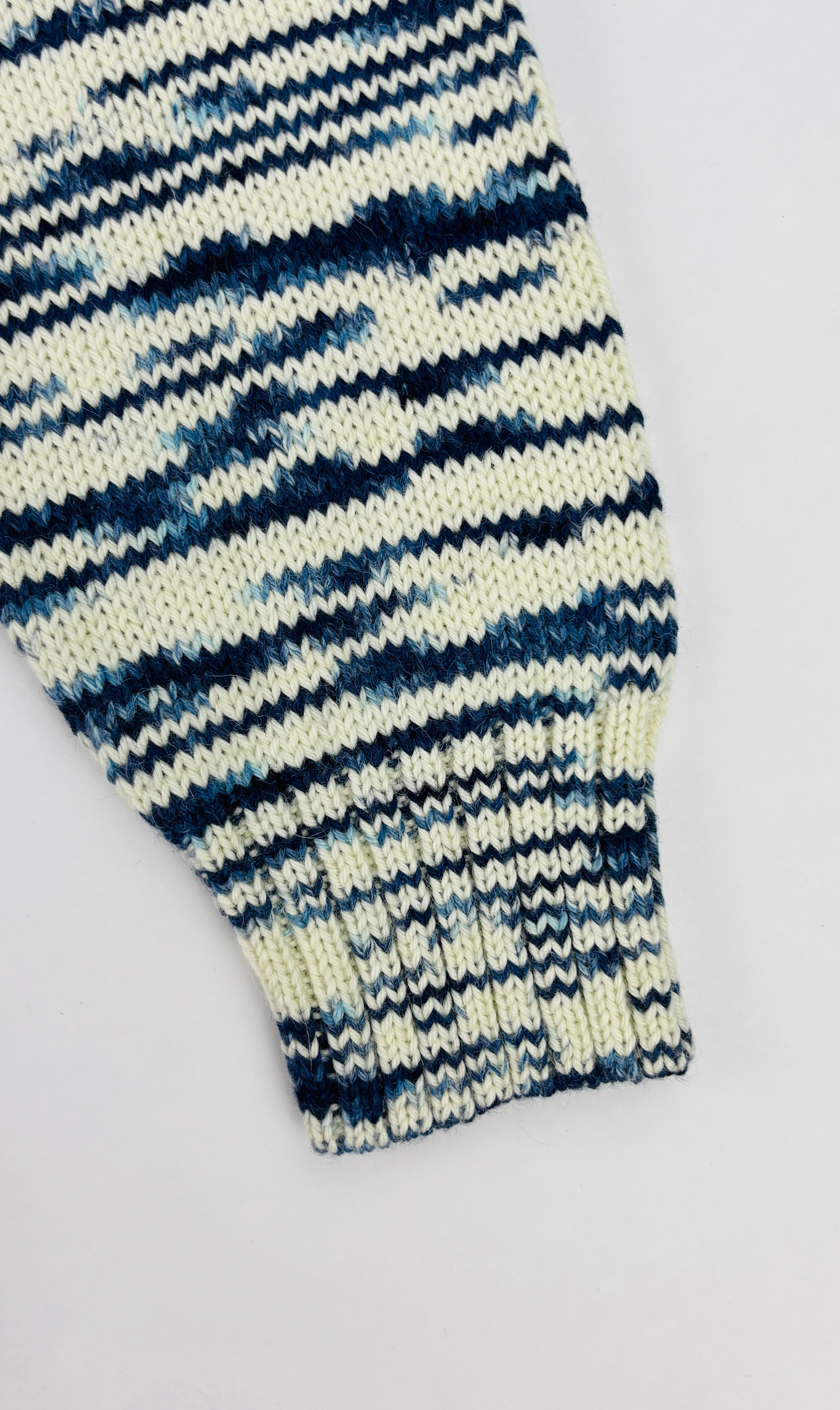 Ärmelansicht des blau weißen Alpaka Hoodie für Herren– weiche, edle Stricktextur.