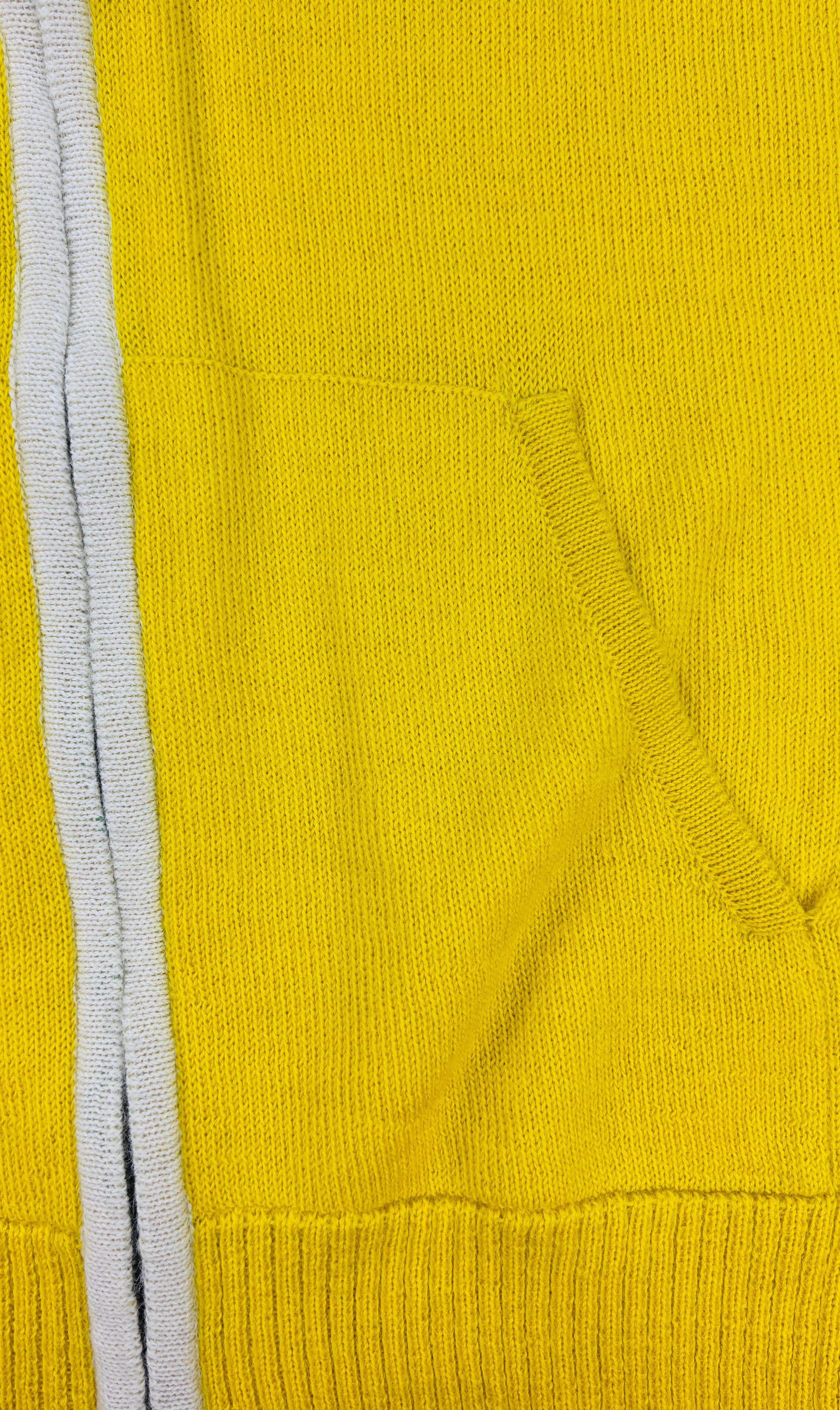 Taschenansicht des gelben Alpaka Hoodie für Herren– weiche, edle Stricktextur.