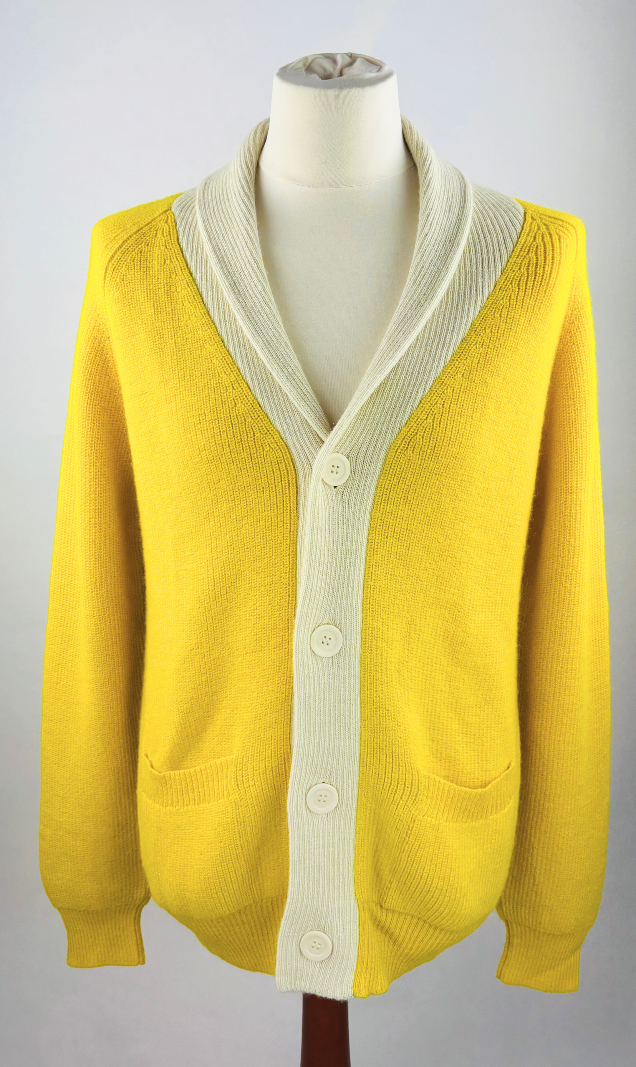 Detailansicht der feinen Strickstruktur der hochwertigen gelbe Alpaka-Strickjacke für Herren.