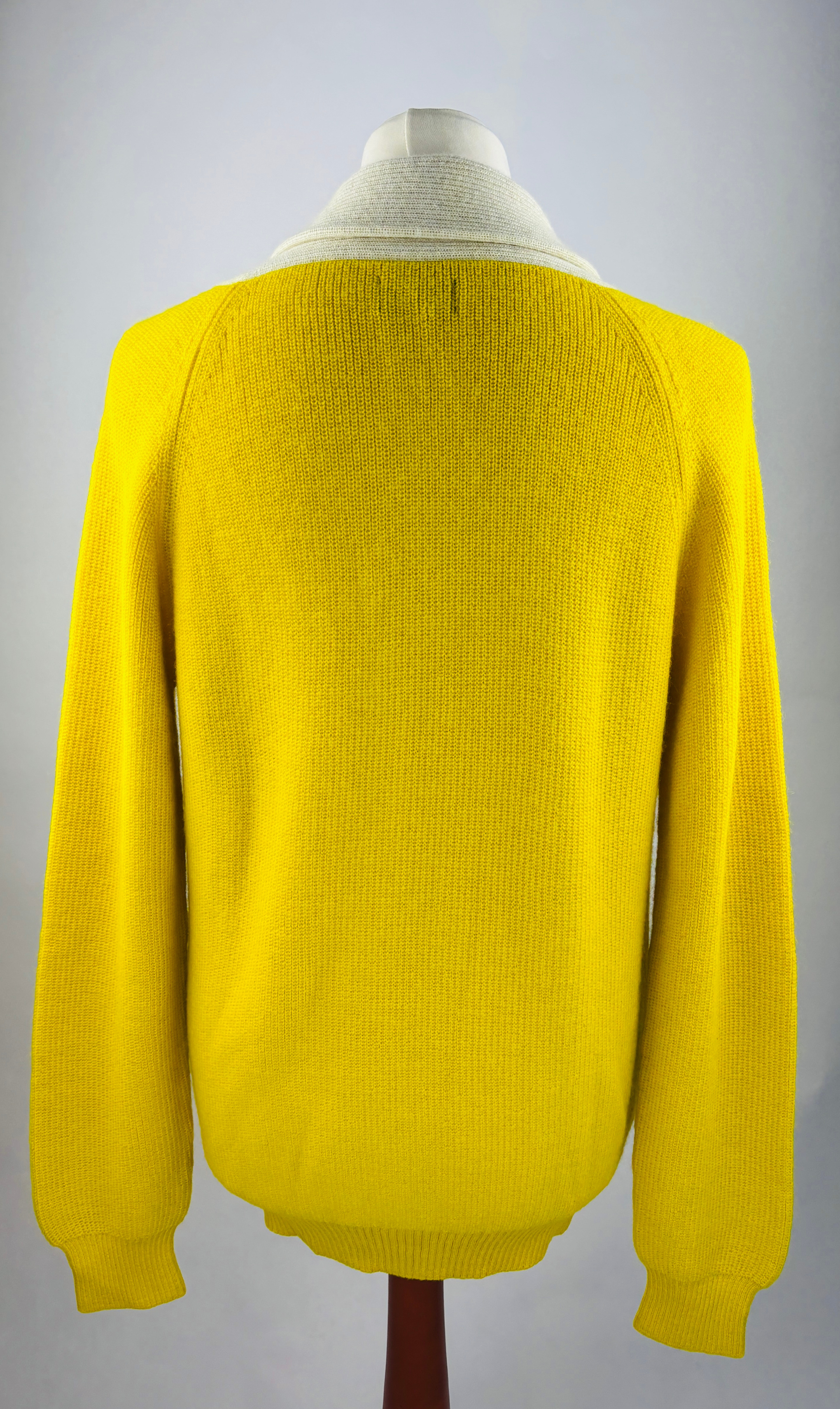 Rückenansicht Detail der feinen Strickstruktur der hochwertigen gelbe Alpaka-Strickjacke für Herren.