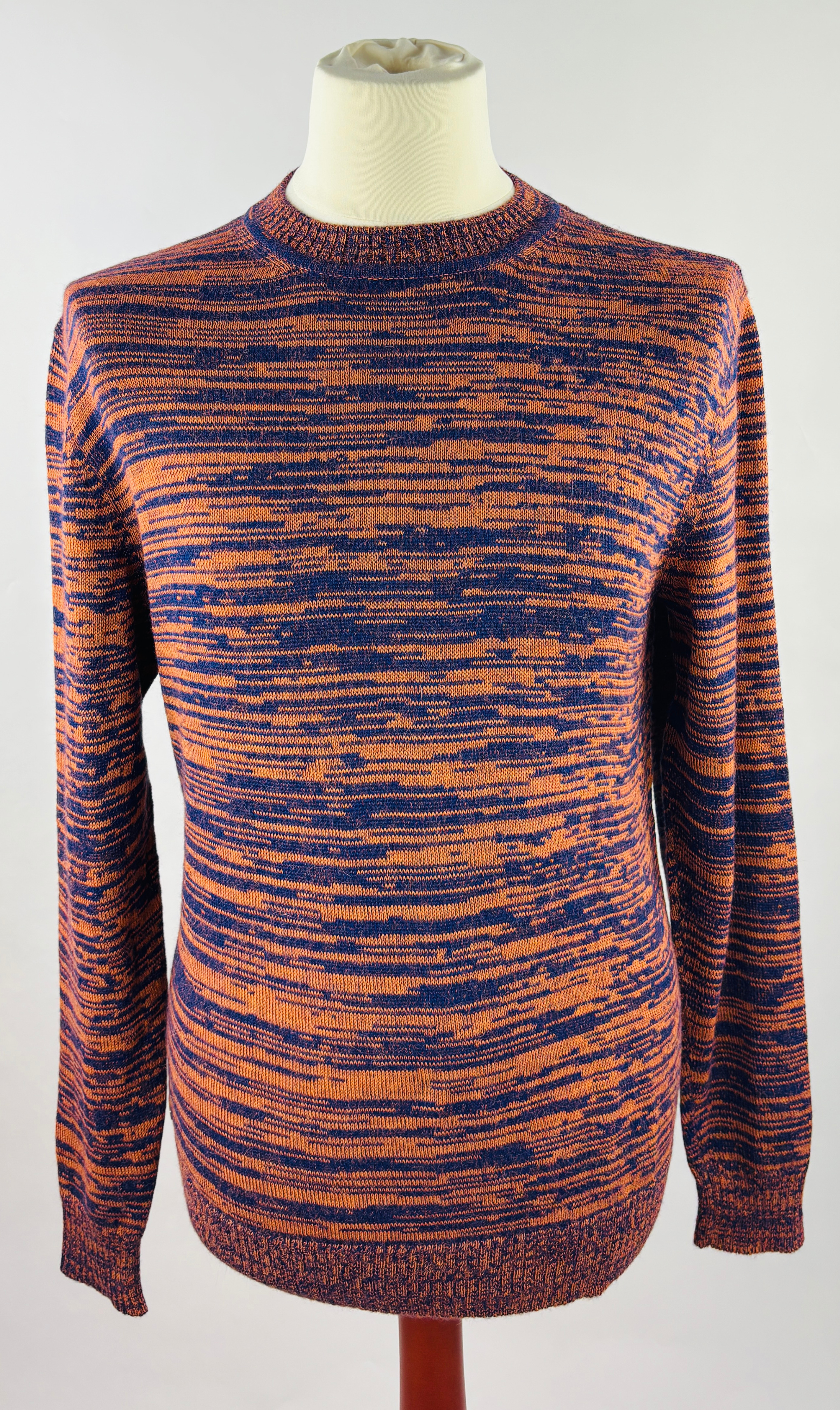 Detailansicht der feinen Strickstruktur des hochwertigen Alpaka-Pullovers in Orange