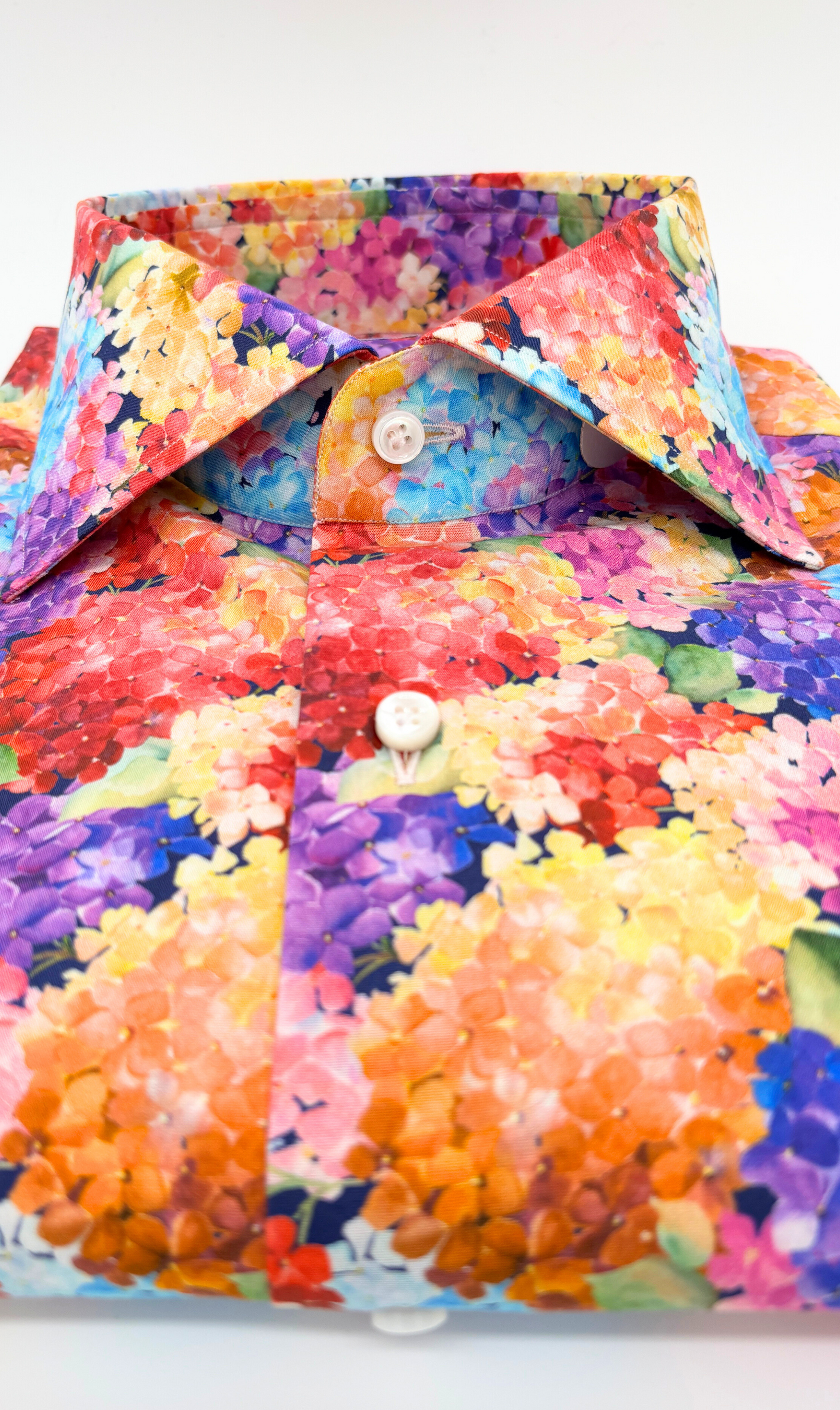 Detailansicht des Softcollar-Kragens und der runden Manschetten des nachhaltigen Herrenhemds mit bunten Hortensien Muster.