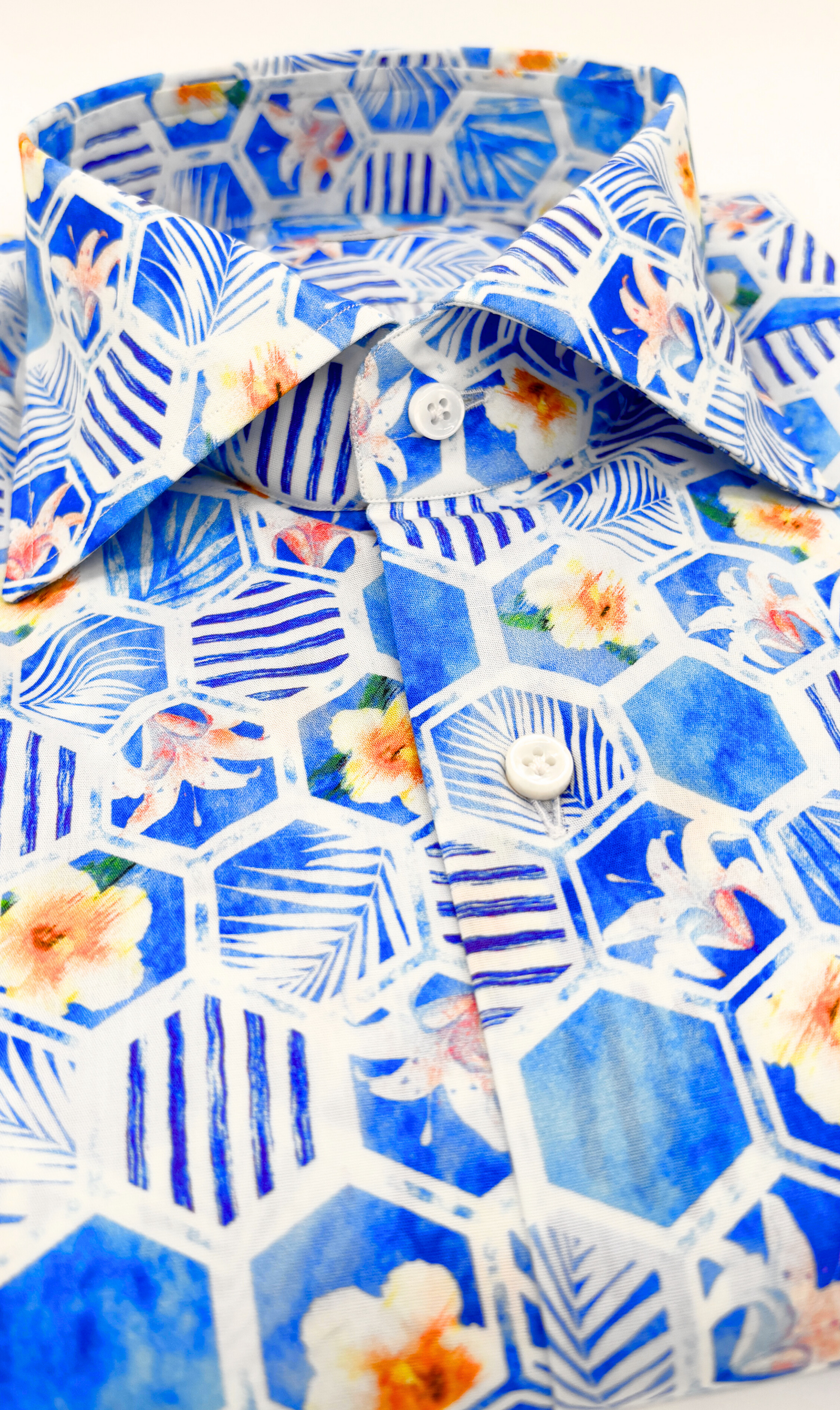 Detailansicht des Softcollar-Kragens und der runden Manschetten des nachhaltigen Herrenhemds mit blauen blumen-Muster.